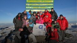 Les quinze participants de la campagne «Voir grand pour l'enfance – Défi Kilimandjaro», accompagnés de leurs guides, sur le faîte de la plus montagne d'Afrique.